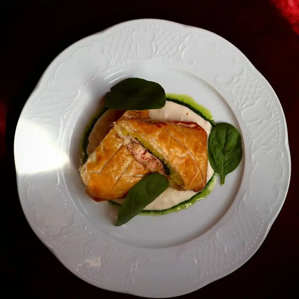 Koulibiac au saumon de l’Ecosse en croûte feuilletée, servi avec une sauce au vin jaune, spécialité franco-slave chez Eva Restaurant Lille.